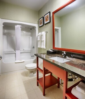 A bathroom with a bathtub, toilet, and sink.