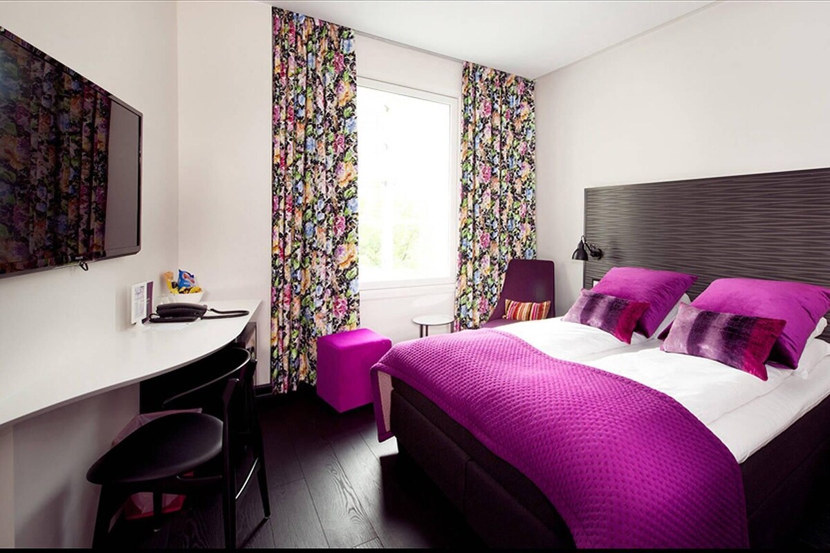 Une chambre moderne avec un grand lit, un bureau et une chaise.