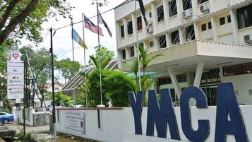 Located near lush greenery, the YMCA building stands proudly with its prominent sign.