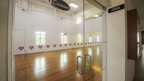 A gym with wooden floors, mirrored walls, and motivational signs.