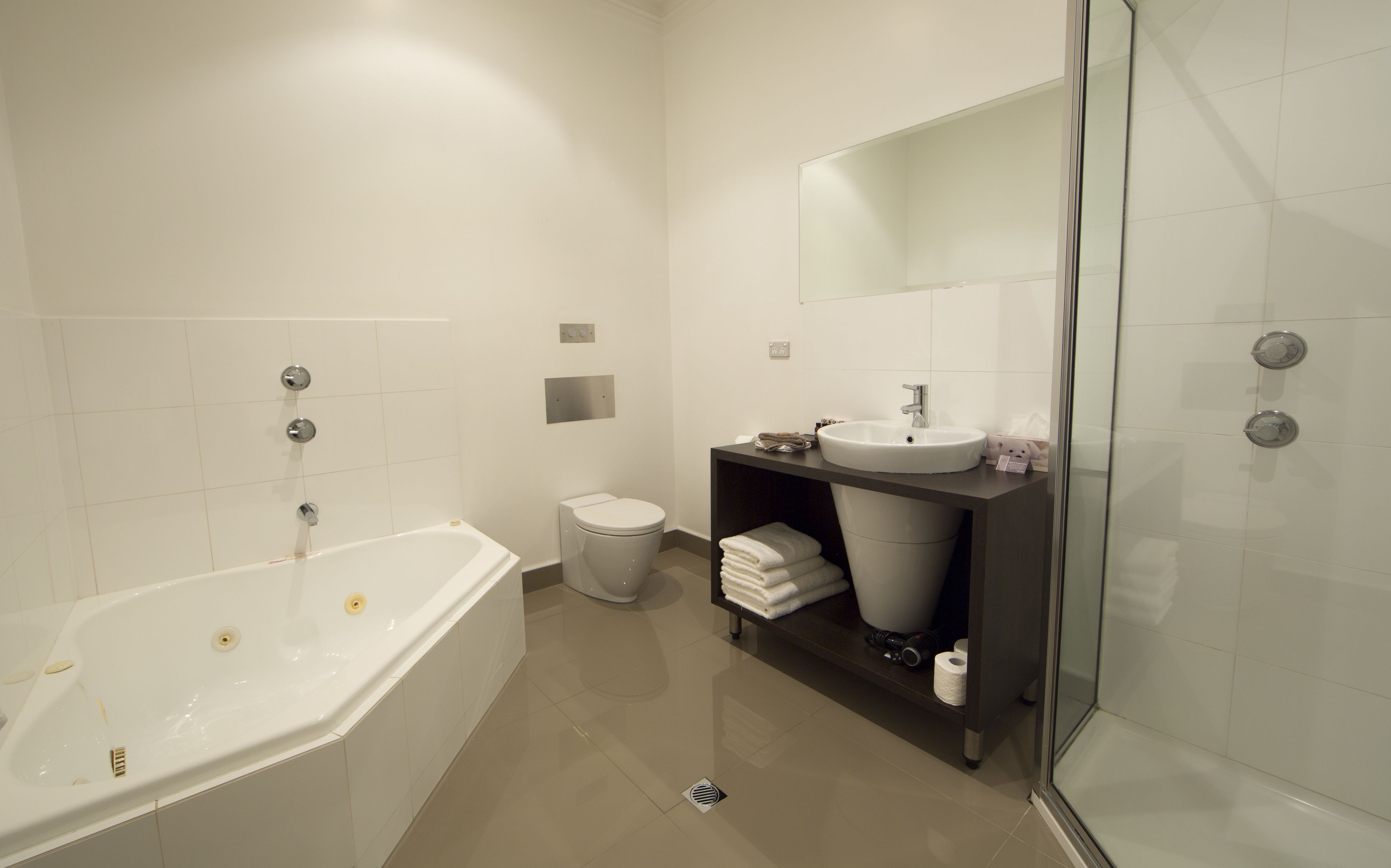 A modern bathroom with a bathtub, toilet, sink, and shower.