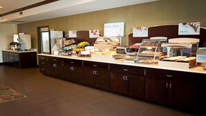 A buffet area with various food options, including bread, eggs, and fruit.