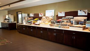 Un espace buffet proposant une variété de plats, notamment du pain, des œufs et des fruits.