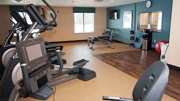 A gym with exercise equipment, a treadmill, and a stationary bike.