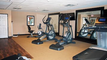 A hotel fitness center with treadmills, elliptical machines, and a stationary bike.