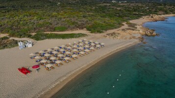 Una playa cerca, sillas reclinables de playa, sombrillas