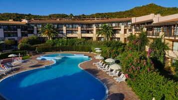 Una piscina al aire libre de temporada, sombrillas