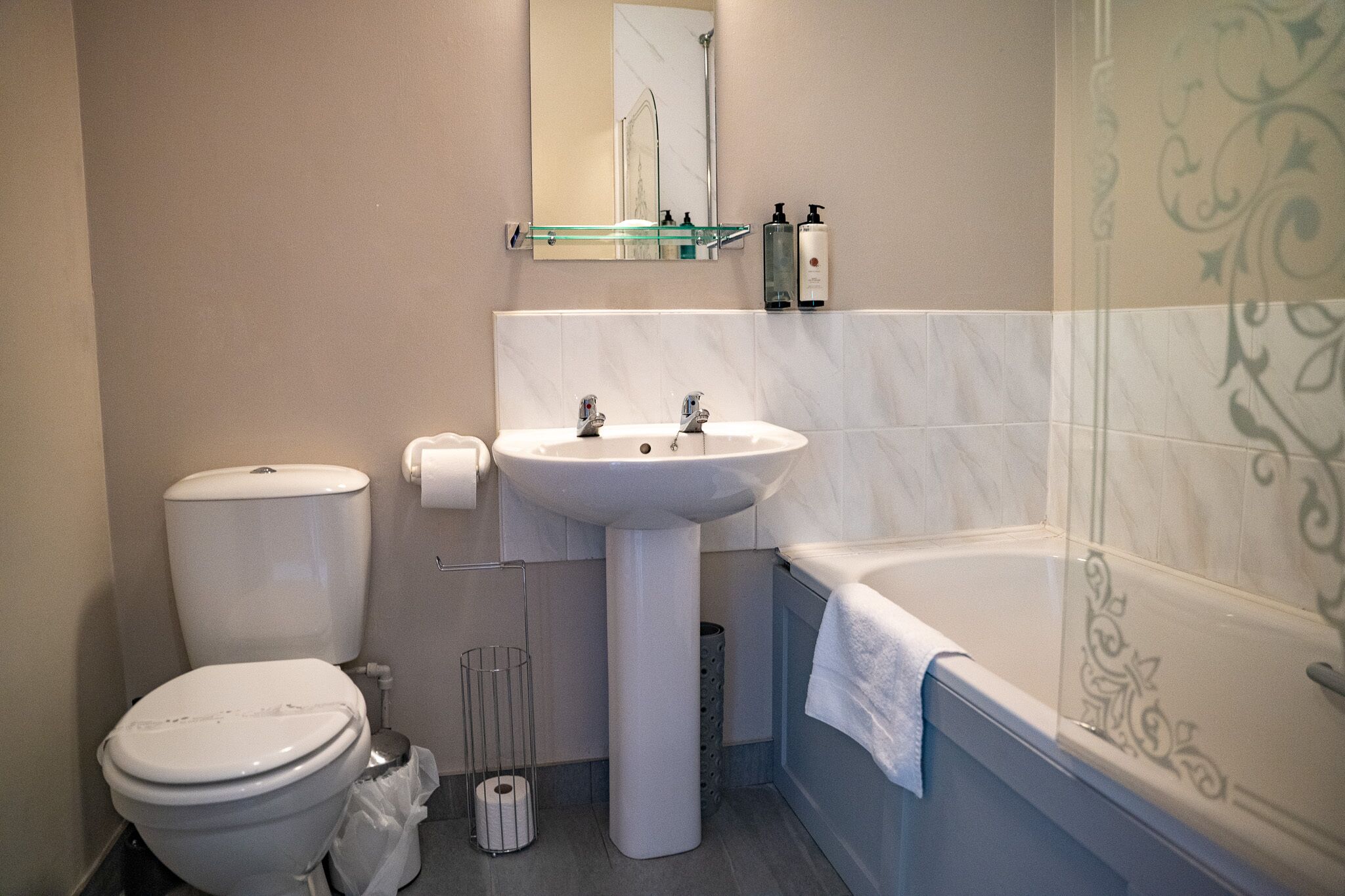 A bathroom with a toilet, sink, and bathtub.