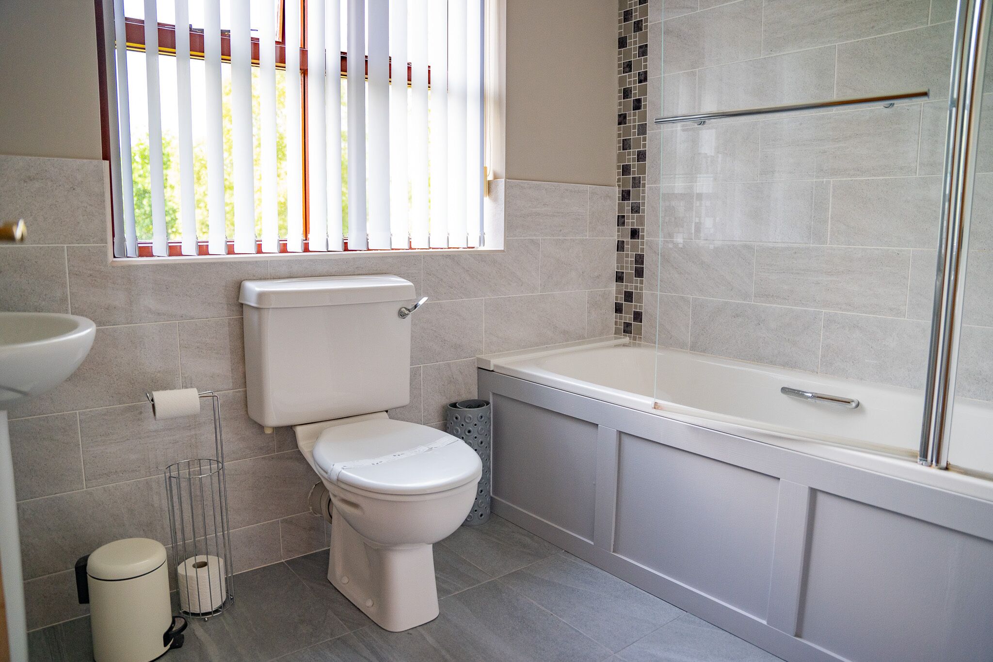 Un baño moderno con inodoro, lavamanos y bañera.