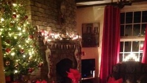A dining area with a Christmas tree, red tablecloth, candles, and a fireplace. - Church View B&B and Holiday Cottages (York)