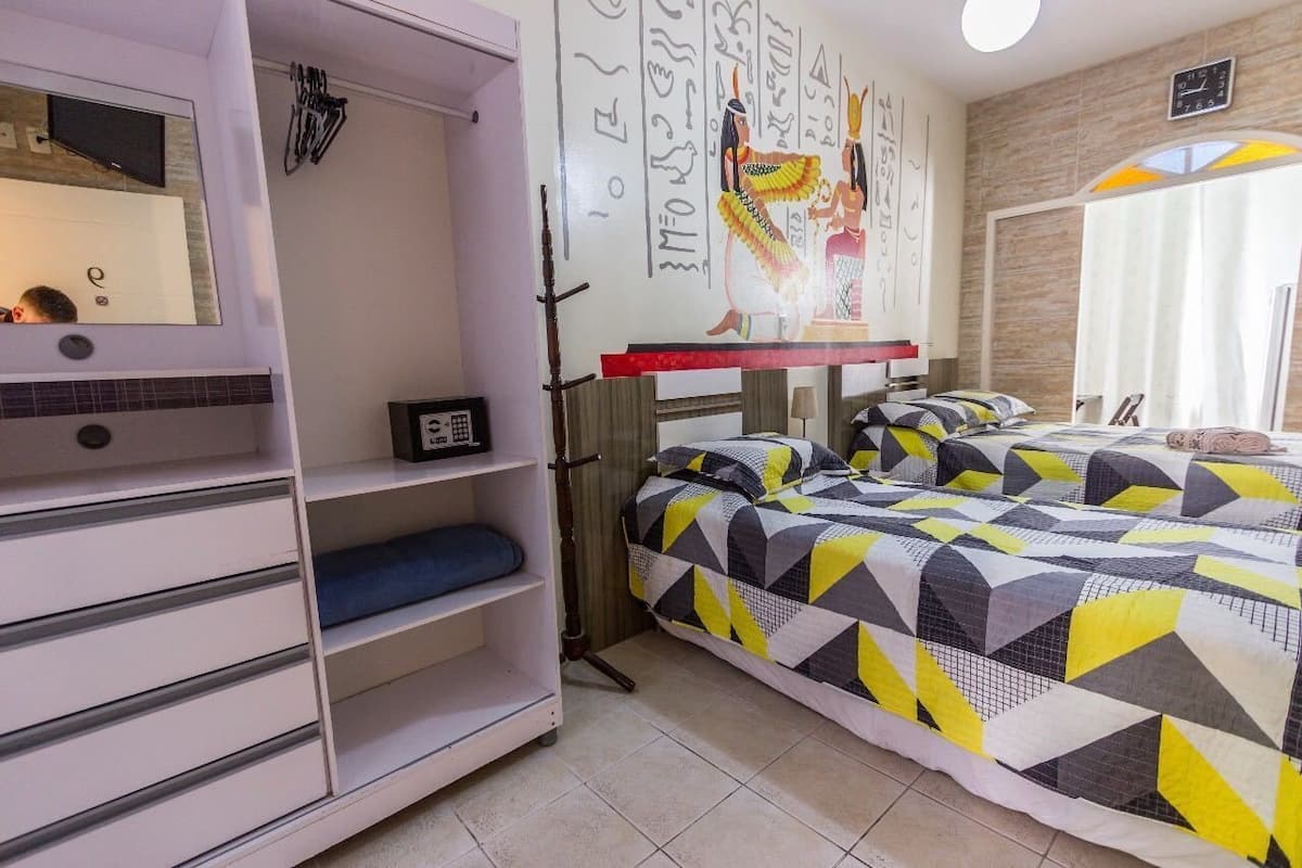 Una camera da letto con un letto, un armadio, uno specchio e una parete con geroglifici egizi.