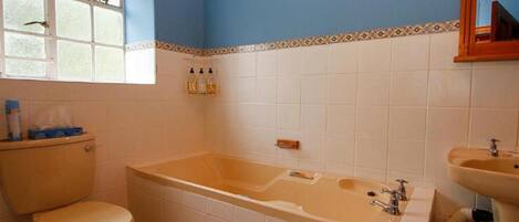 A bathroom with a bathtub, toilet, and sink.