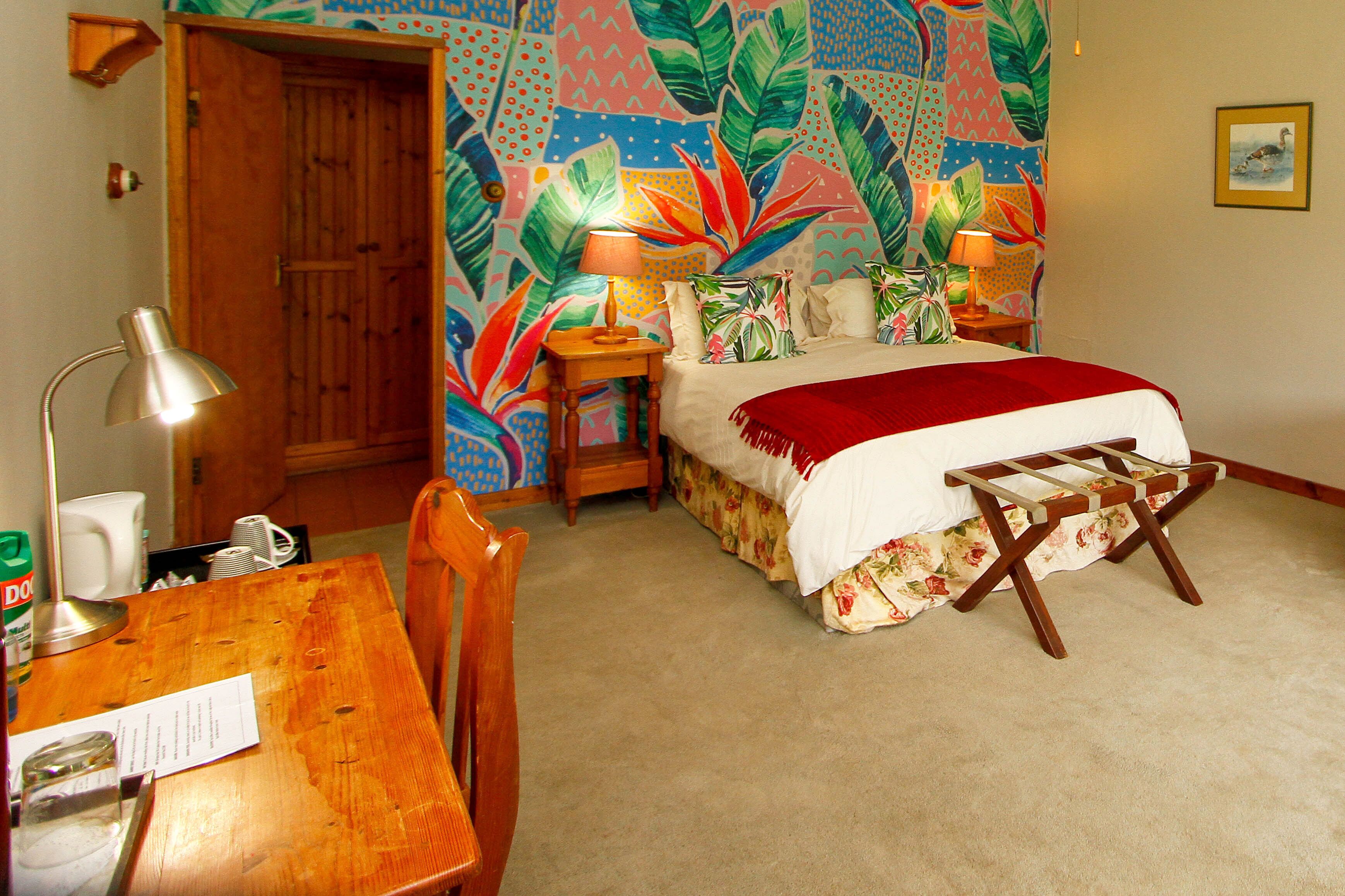 A bedroom with a bed, bedside tables, a desk, and a chair.