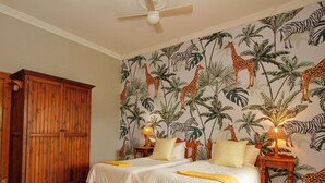 A bedroom with two beds, wooden wardrobe, and a ceiling fan. - SpionKop Lodge (Ladysmith)