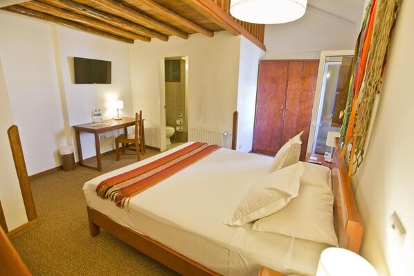 A hotel room with a bed, a desk, a chair, a television, and a wardrobe. - Tierra Viva Cusco Centro (Cusco)