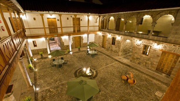 A courtyard with stone flooring, outdoor seating, and a central fountain. - Tierra Viva Cusco Centro (Cusco)