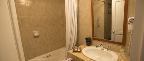 A bathroom with a bathtub, a sink, a mirror, and a towel rack.