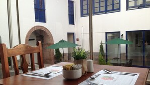 A dining table set with a menu, utensils, and a bowl of breadsticks. - Tierra Viva Cusco Centro (Cusco)