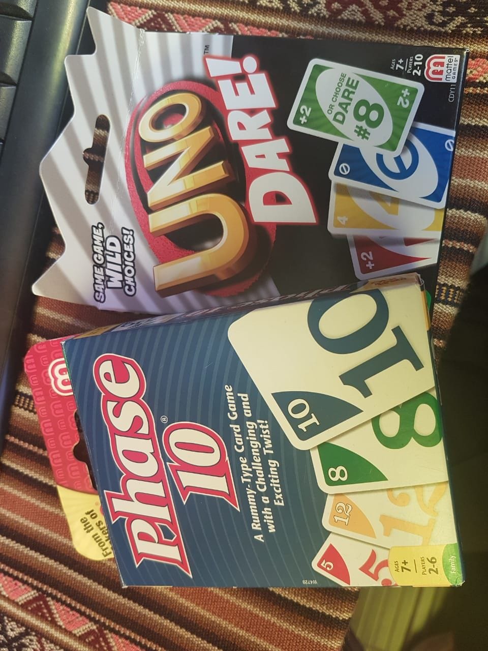 Una caixa de joc amb el títol 'UNO DARE' i una caixa de joc 'Phase 10'.