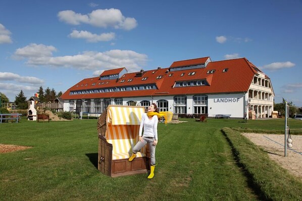 A building with a red roof and a sign that reads "LANDHOF".