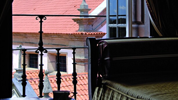 Ein Zimmer mit Blick auf ein Gebäude mit rotem Dach und einem Glockenturm.
