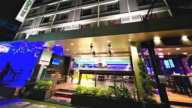 A multi-story hotel with a brightly lit entrance and outdoor seating area. - iCheck inn Nana by Aspira (Bangkok)