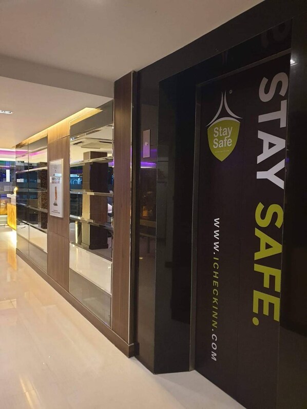 A modern interior with a 'Stay Safe' sign and a website address.