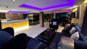 A modern hotel lobby with a reception desk, seating area, and a bar. - iCheck inn Nana by Aspira (Bangkok)