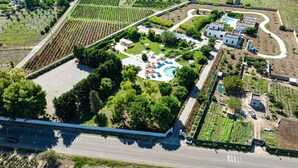 An aerial view of a resort with a swimming pool, guest rooms, and landscaped gardens. - Tenuta San Nicola (Novoli)
