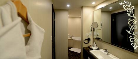 Une salle de bain équipée d’un lavabo, d’un miroir et d’un porte-serviettes.