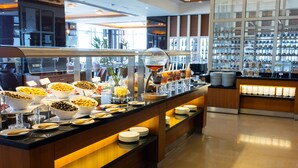 En buffet sektion med forskellige retter og et udstilling af flasker.