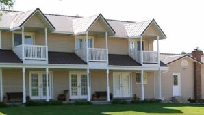 A two-story house with a balcony on each floor, a front porch, and a chimney. - Bryce Canyon Livery Bed & Breakfast (Tropic)