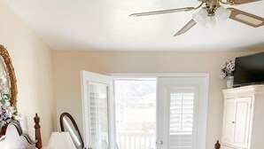 A bedroom with a bed, a dresser, a chair, a lamp, and a ceiling fan. - Bryce Canyon Livery Bed & Breakfast (Tropic)
