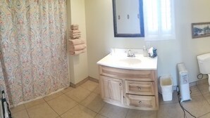 A bathroom with a white sink, wooden vanity, a toilet, a trash bin, and a heater. - Bryce Canyon Livery Bed & Breakfast (Tropic)