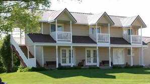 A multi-story building with a porch, a staircase, and a well-maintained lawn. - Bryce Canyon Livery Bed & Breakfast (Tropic)