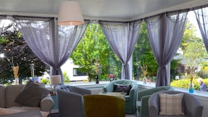 A cozy living room with a sofa, armchairs, and a small table. - Atholl House Skye (Dunvegan)
