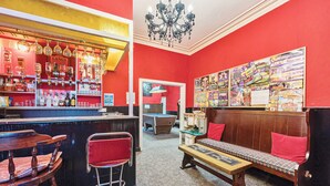 Angolo bar con parete rossa, una panca di legno e un tavolo da biliardo.