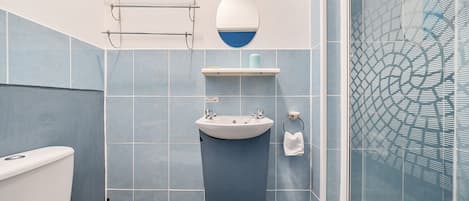Un baño con inodoro, lavamanos y ducha.