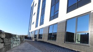 A modern building with large windows and a paved walkway. - Tananger Apartment Hotel  (Sola)