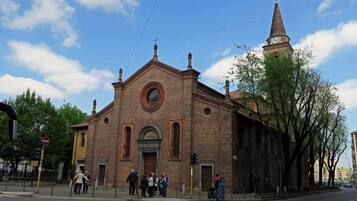 A historic church with a prominent bell tower and a large circular window.