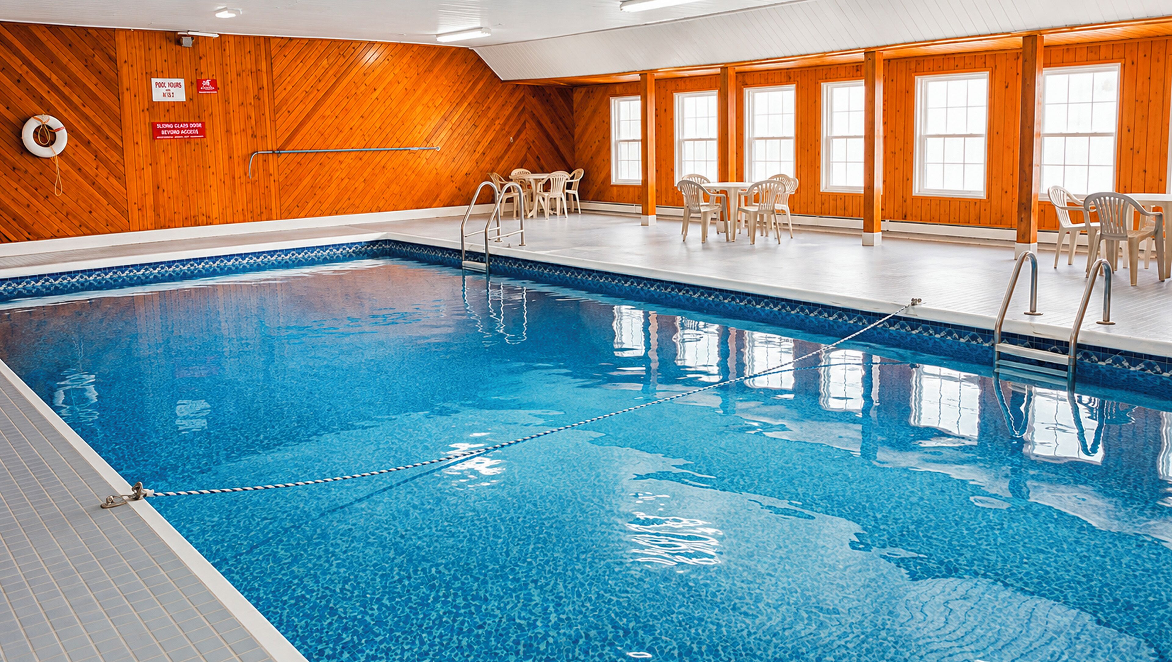 Una piscina interior con paredes de madera y suelo de baldosas.