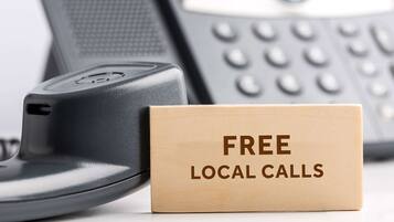 A telephone handset and a cardboard box with "FREE LOCAL CALLS" printed on it.