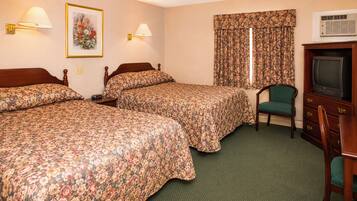 A hotel room with two beds, a chair, a television, and a window with curtains.