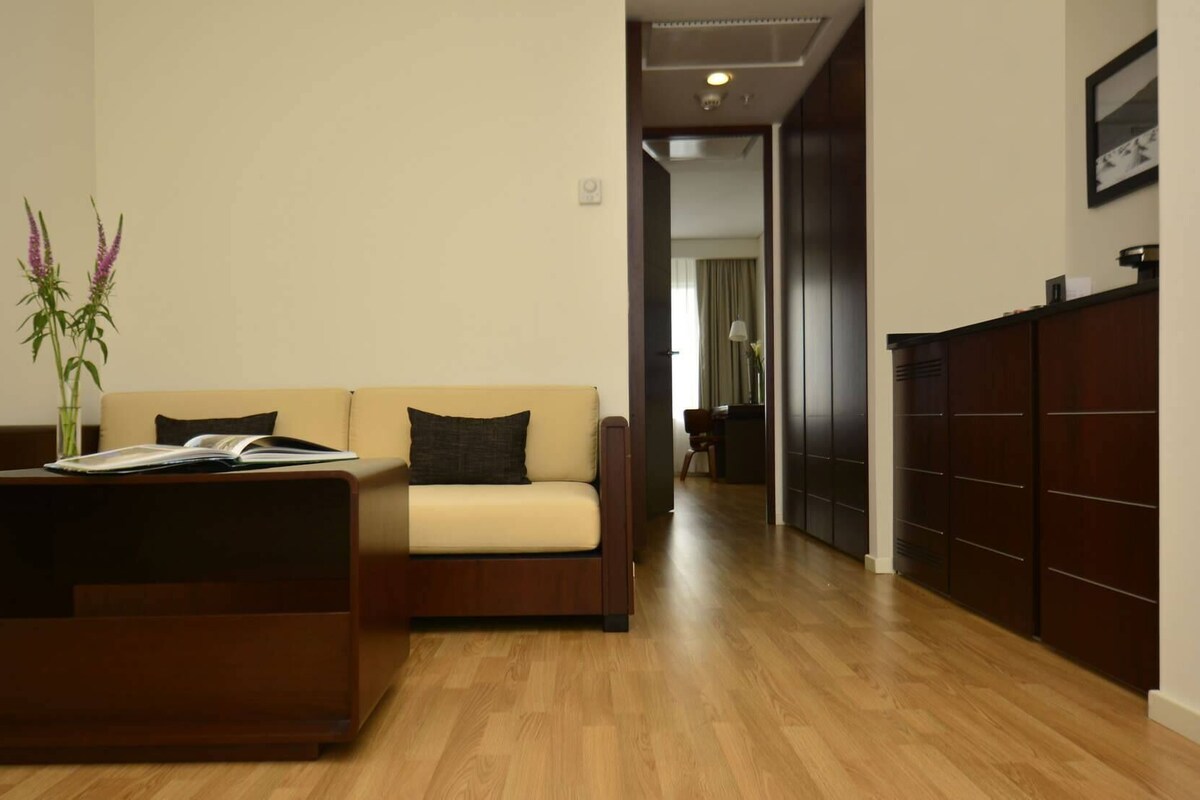 Una sala moderna con un sofá, una mesa de centro y piso de madera.