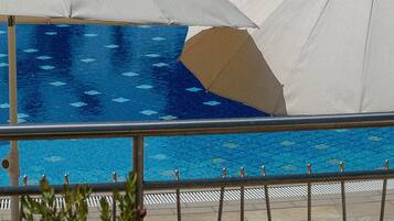 Una piscina con lettini e ombrelloni.