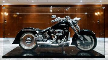 A motorcycle on display in a glass case with a wooden background.