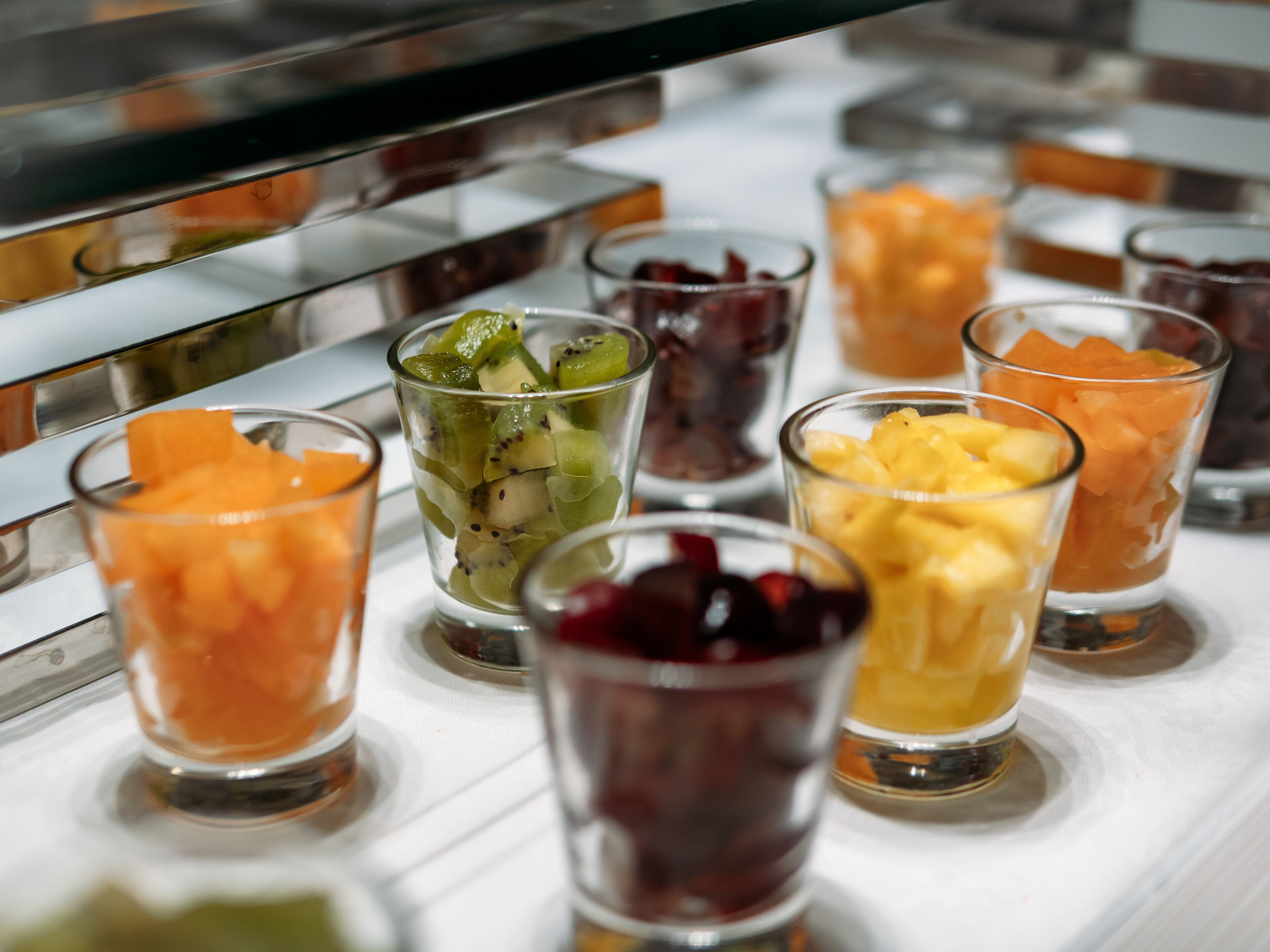 A selection of fruit juices in small glasses on a counter.