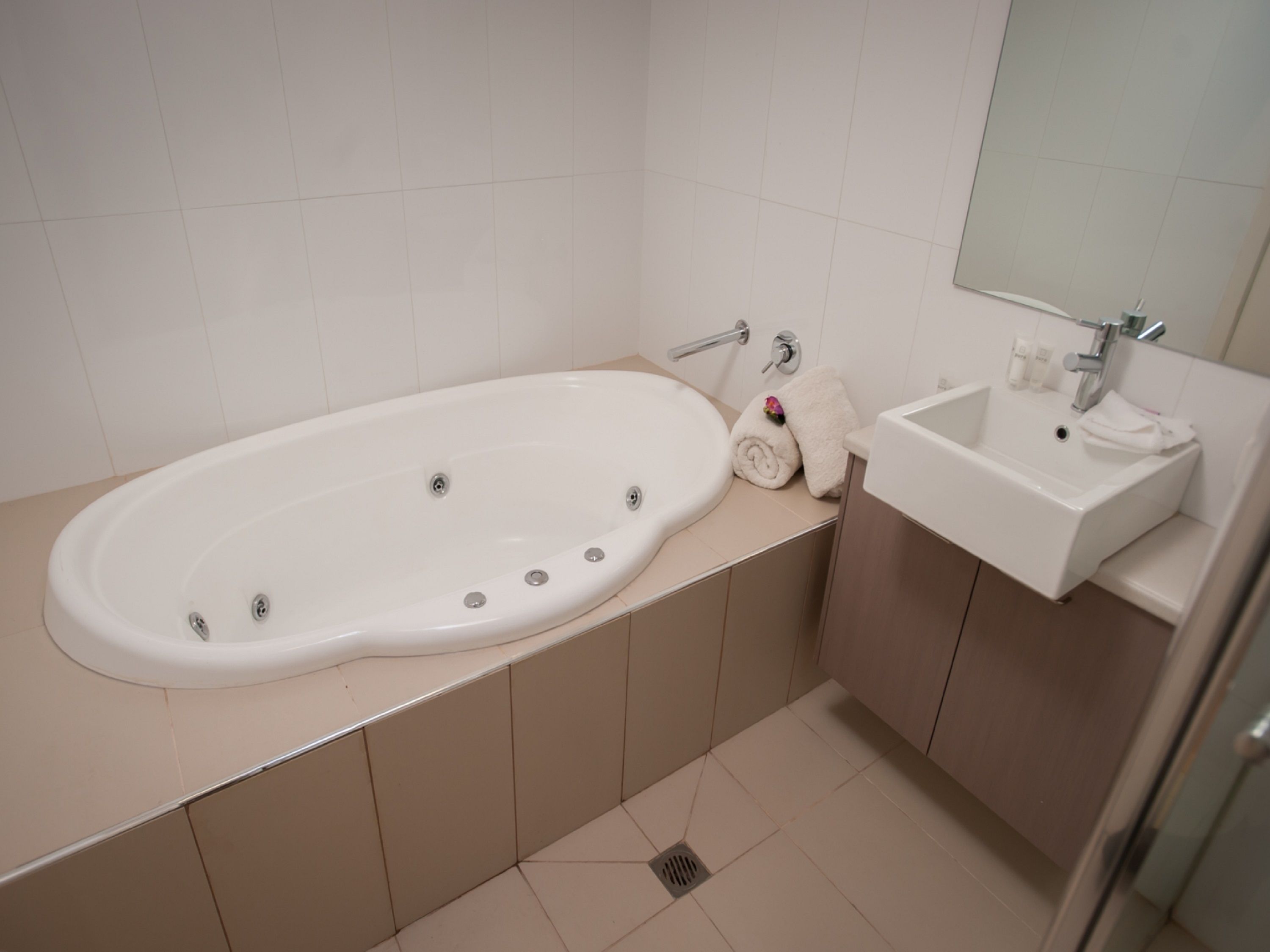 Een badkamer met een bad, een wastafel en een spiegel.