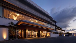 Un hotel moderno con fachada de vidrio, acceso cubierto e interior bien iluminado.
