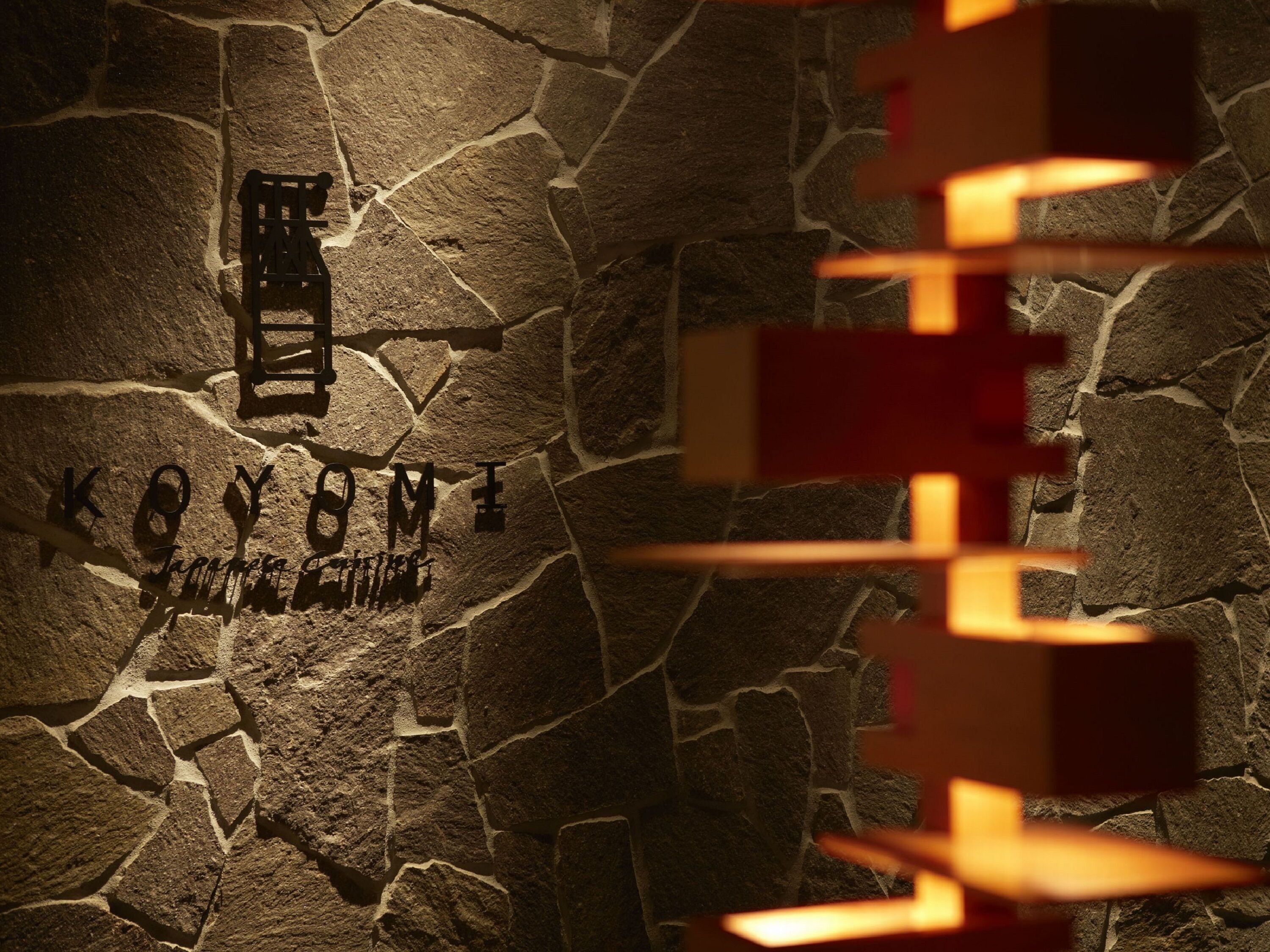 A stone wall with carved text and a wooden ladder.